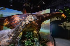 Dinosaurusnäyttelyssä suuri pitkäkaulainen dinosaurus ja sen edessä pienempi dinosaurus.