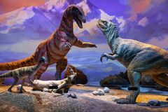 Dinosaurusten dioraama: kaksi suurta petodinosaurusta vastakkain, pienempiä dinosauruksia ja vuoristomaisema taustalla.
