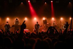 Näkymä Pakkahuoneen lavalle, jolla Apulannan muusikot esiintyvät. Lava hohtaa keltaisessa ja punaisessa valaistuksessa. Etualalla näkyy konserttiyleisöä.