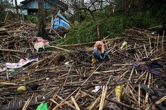 En rohingya-kvinna sitter i sitt förstörda hus i flyktinglägret Basara i staden Sittwe. Foto: KUH via AFP/Lehtikuva