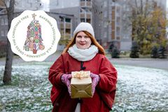 Kuvassa punanuttuinen nainen pitää lahjaa sylissään talvisessa maisemassa.
