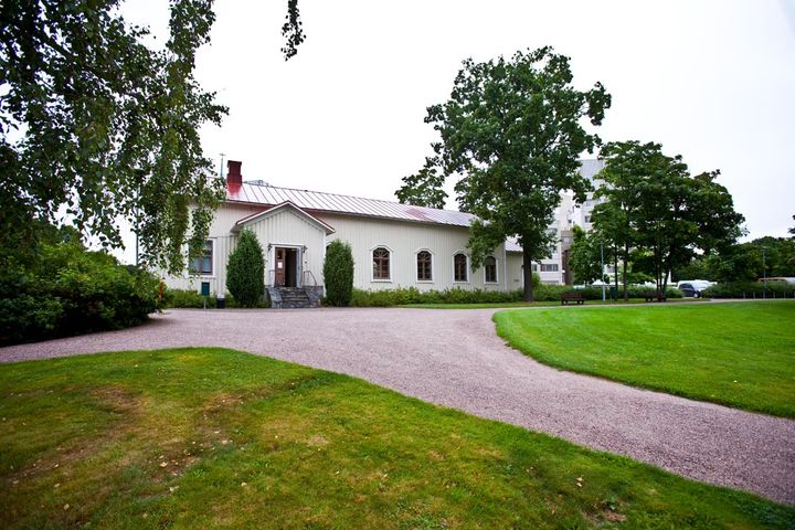 Valkoinen lautaverhottu kappeli puiden ympäröimänä