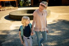 En förstklassare med ryggsäck tillsammans med sin mamma.