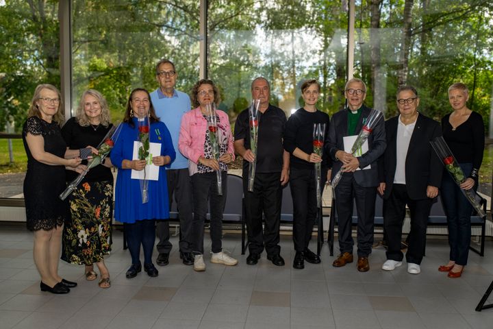 Gruppbild med rosor: Anne Arkonaho, Irene Ponkula-Karlsson, Anne-Maria Laukkarinen, Juha Ilomäki, Arja Pietarila, Eero Laasonen, Anni Lummekoski, Jyrki Myllärniemi, Hannu Hätönen ja Monika Meling.