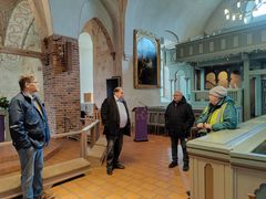 Några personer står intill altarringen i Esbo domkyrka.