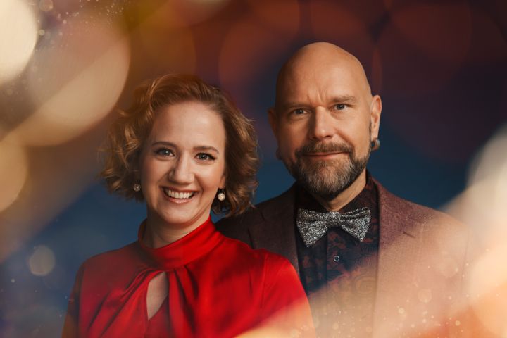 En kvinna i röd festblus och en man iklädd fluga och kavaj.