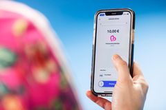 En närbild där en person håller i en smarttelefon och på skärmen donationsuppgifter.