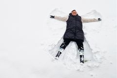 Mirja Miettinen is making an angel in the snow.
