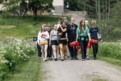 Kuvassa joukko nuoria ulkona hiekkatiellä.