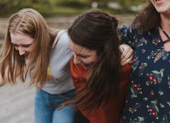 Kuvassa on kolme iloisen oloista nuorta.