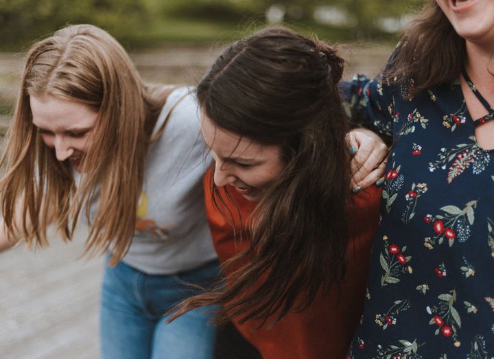 Kuvassa on kolme iloisen oloista nuorta.