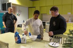 Cooking club participant Daniel and club leader Eelis cooking together.