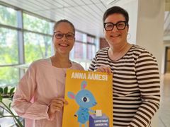 Tiina Hänninen ja Mirja Miettinen käsissään Lastenvaalien juliste, jossa on Lastenkirkon piirroshahmo Päkä-lammas ja teksti: Anna äänesi!