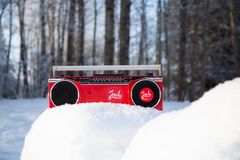 Red Jouluradio in a snowbank, basking in the sunlight.