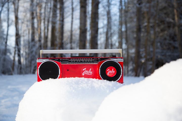 Red Jouluradio in a snowbank, basking in the sunlight.
