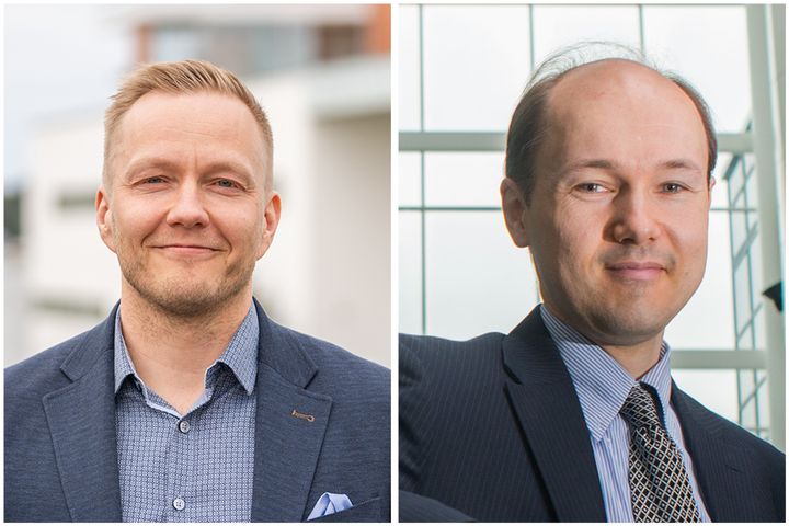 Kaksi miestä katsoo kameraan..