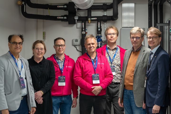 Ihmisiä seisomassa sisätiloissa tutkimusympäristössä.