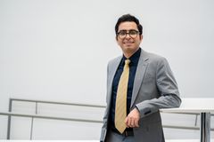 Seyed Mahoor Ebrahimi katsoo kameraan ja hymyilee. Hänellä on silmälasit ja hän on pukeutunut pukuun ja kravattiin.