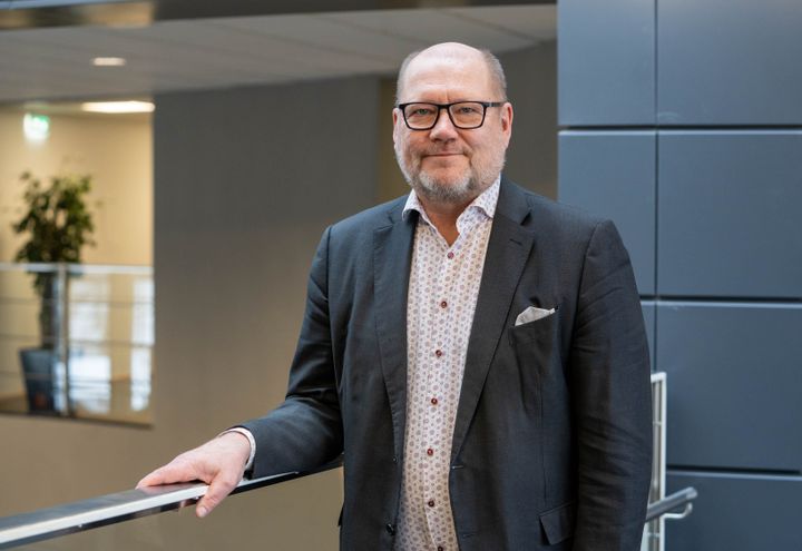 Juha Gröhn nojaa kaiteeseen ja hymyilee