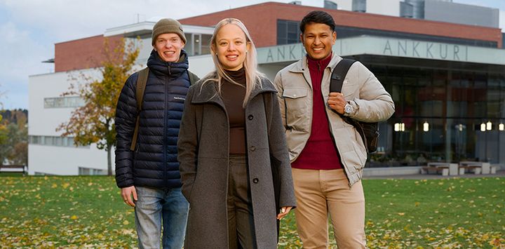 Kolme henkilöä seisoo vierekkäin kampusalueella Vaasan yliopistossa.