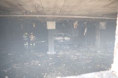 Palomiehiä palaneessa parkkihallissa.