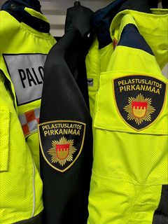 Pelastustoimen virka-asusteissa on pelastuslaitoksen vaakuna.