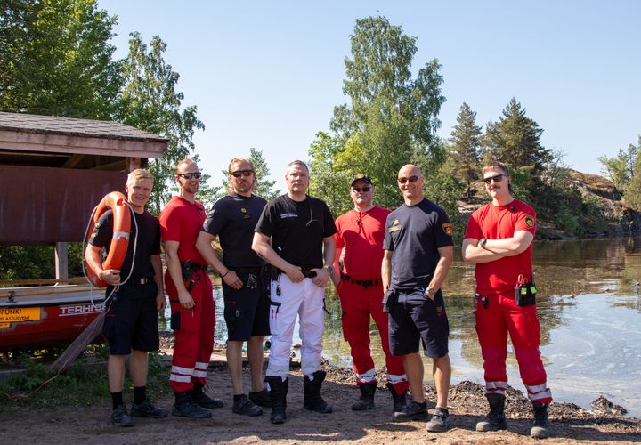 Pelastus- ja ensihoitopalvelun henkilöstöä virkavaatteissa uimarannalla.
