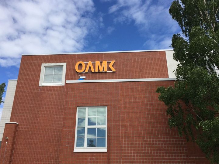 Oamk Kontinkankaan kampuksen punatiilinen rakennus, jossa on Oamk-logo.