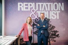 Reputation and Trust Analyticsin uusi toimitusjohtaja Salla Ketola ja väistyvä toimitusjohtaja Harri Leinikka taustanaan teksti "Reputation & Trust".