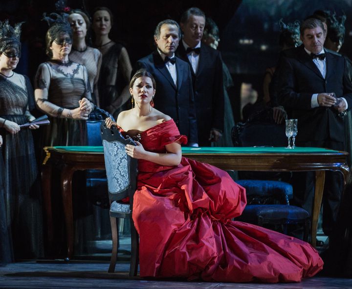 Nainen Violettan roolissa upeassa punaisessa Valentinon puvussa La Traviata -oopperassa.