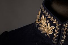 Kuvassa on tummansininen univormu, jonka kauluksessa on kullattuja lehtikoristeita.