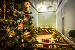 Jouluvaloin ja -koristein koristeltu palatsin käytävä, jossa näkyy joulukuusi etualalla.