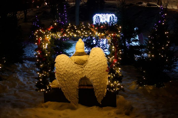 Valokuva valaistusta enkelistä Näsinpuistossa, ympärillä joulukoristeita ja lunta.