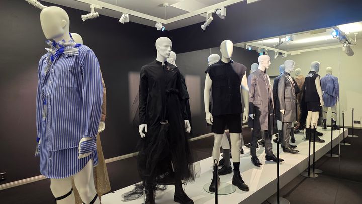 Mannekiineja näyttelyssä esittelemässä erilaisia miesten asuja ja tyylejä.