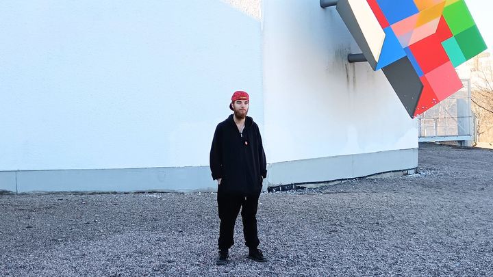 Mustiin vaatteisiin pukeutunut mies seisoo Heurekan edessä.