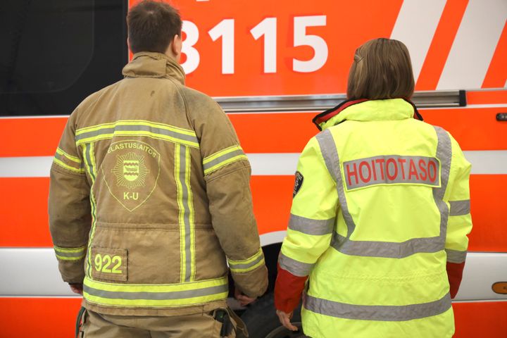 Palomies ja ensihoitaja vierekkäin selkäpuolelta