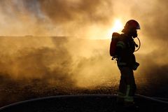 Palomies savussa ja auringonnousussa.