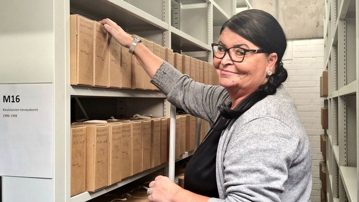 Arkistopalveluvastaava Sari Tonisson poimii arkistokansiota VAKEn arkistossa.
