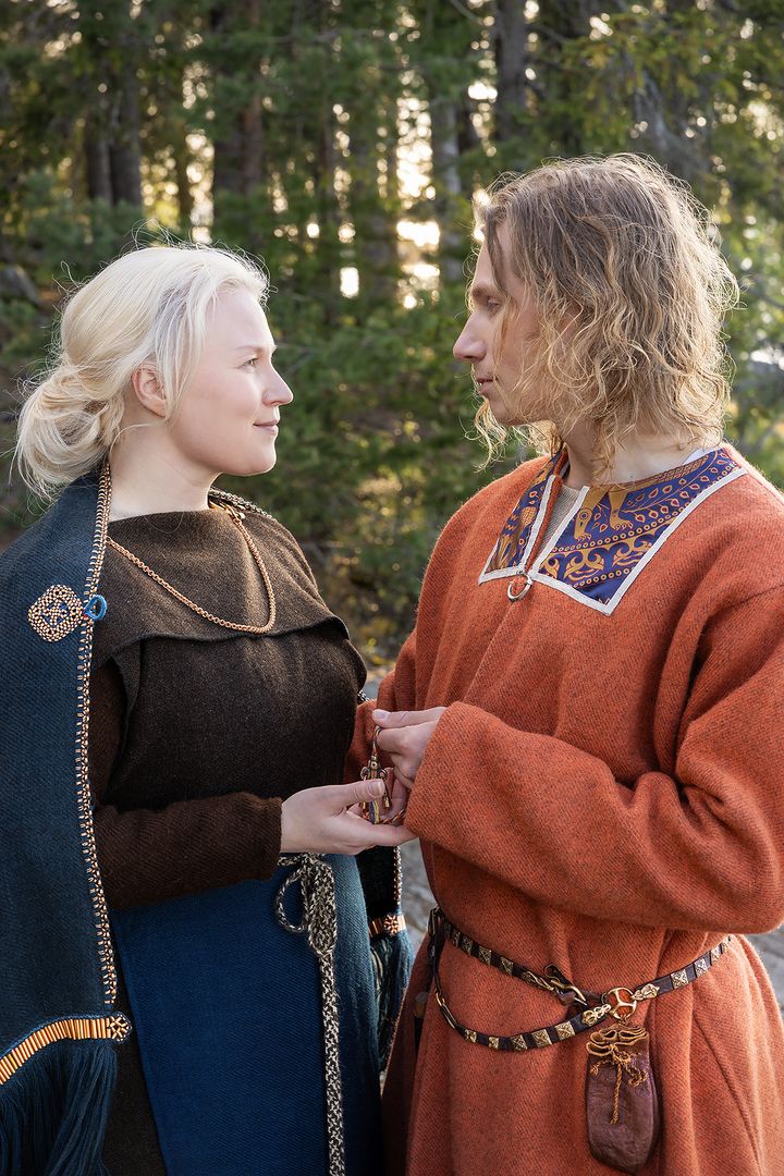 Kaksi henkilöä keskiaikaisissa puvuissa katsoo toisiaan metsän keskellä.