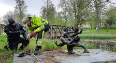 Kaksi miestä veistoksen vieressä.