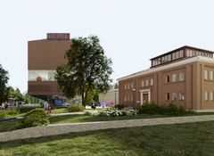 Kaksi punatiilistä rakennusta, vanha makasiini ja korkea moderni rakennus.