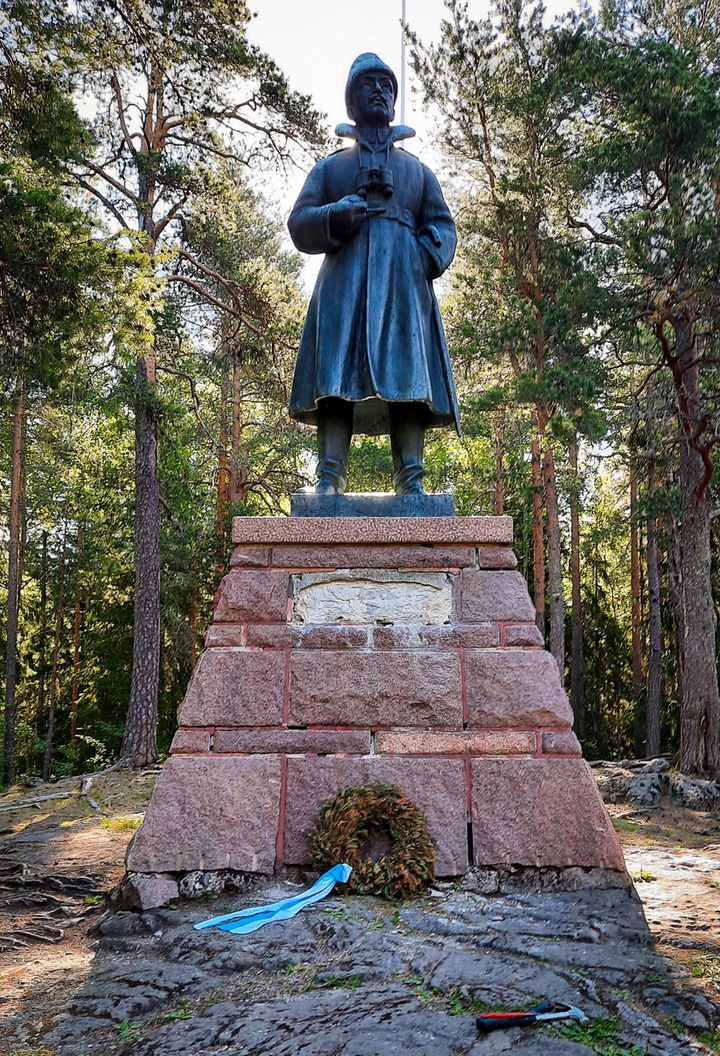 Miestä esittävä korkea patsas graniittijalustalla.