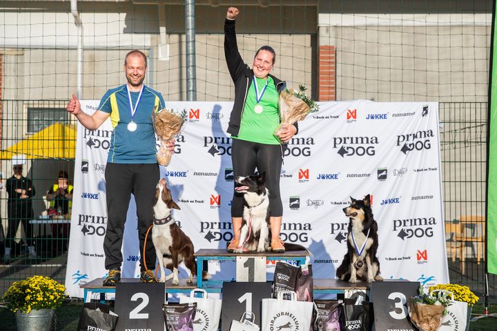 Palkintokorokkeella Katariina Kuiro ja bordercollie Wendi tuulettamassa kultamitalia, Pasi Kangas ja bordercollie Skye tuulettamassa hopeaa ja bordercollie Gee yksin pronssikorokkeella.