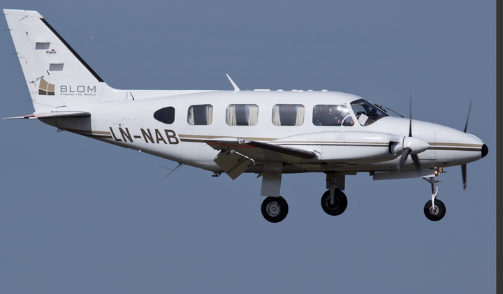 Sinistä taivasta vasten lentävä pieni, kaksimoottorinen lentokone.