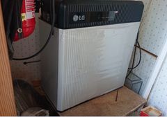 Kuluttaja-akku asennettuna paikalleen. Hopeanvärinen alapuoli, musta yläpuoli. Sammutin kuvan reunassa vasemmalla puolella.