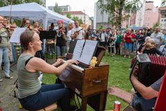 Esiintymässä Orivesi All Stars -pelimannikollektiivi ulkona Oulun keskustassa, ympärillä monenikäinen yleisö nauttii esityksestä.