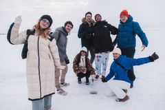 Seitsemän ihmistä seisoo ja kyykistyy hymyillen meren jäällä avannon ympärillä. Heillä on talvivaatteet.