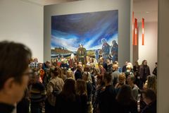 Alt-teksti: Ihmisjoukko tutkii suurta värikästä taideteosta museossa.