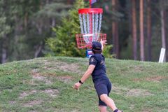 mies heittää frisbeegolfia metsässä
