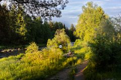 Maisemakuva Koitelinkoskesta, jossa näkyy metsää ja joki. Keskellä on pyöreä katseluikkuna, osa Antti Laitisen teosta "Olet Tässä".